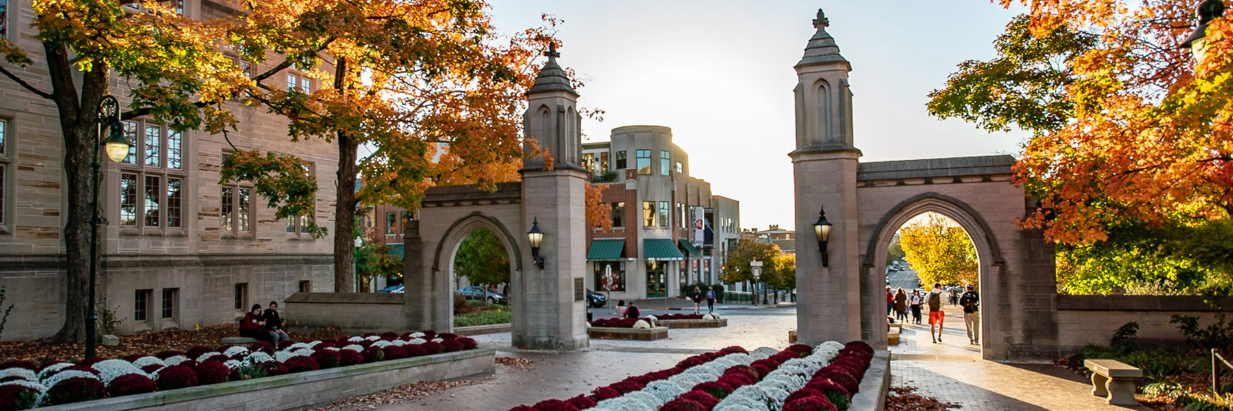 Looking through the Sample Gates onto Kirkwood in autumn with students coming and going.